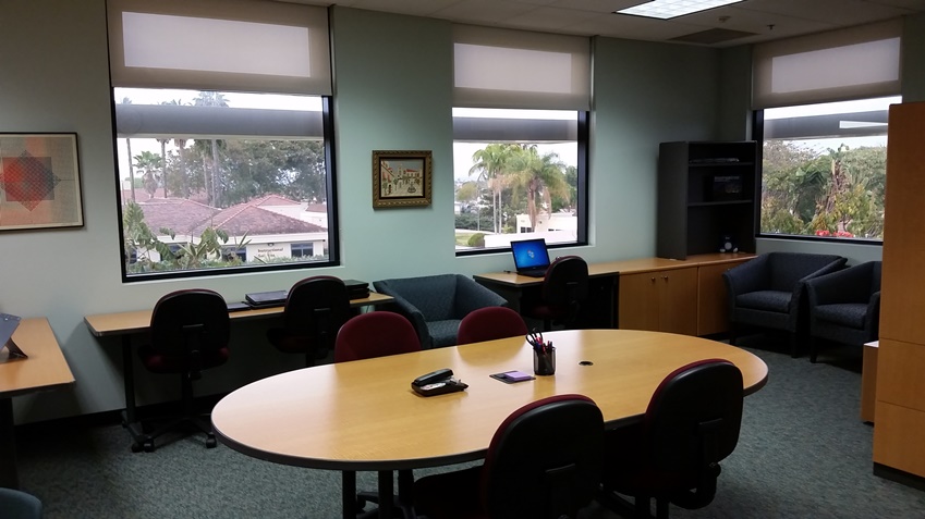 Large conference table with chairs. Laptops are available for use in this room.